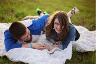 a couple laughing while on a picnic